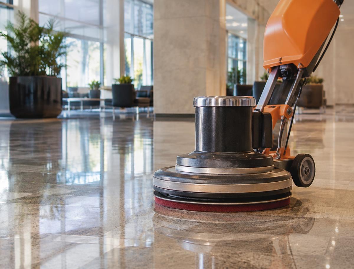 Floor buffer machine polishing a gleaming hard floor in a lobby